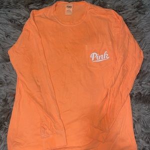 Flash on & off pictures of an orange Victoria Secret Pink long sleeve shirt